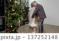 Family celebrating holiday cheer, dad spinning cheerful young daughter near sparkling christmas tree, sharing joyful seasonal moment together 137252148