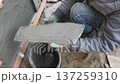 A builder faces the basement of a house with a wild stone. Flat for cladding, tabata on the construction site. 137259310