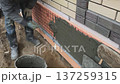 A builder faces the basement of a house with a wild stone. Flat for cladding, tabata on the construction site. 137259315