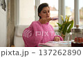 Indoor scene of woman speaking into microphone while reading 137262890