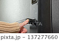 A woman opens a modern smart door lock with a digital keypad and biometric fingerprint access. 137277660
