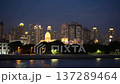 Nighttime Cityscape Reflecting Warm Glow. Peaceful River Scene Under Luminous City Skyline 137289464