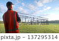 Project Manager Dressed In Safety Attire Observes Crew Working On Evolving Steel Framework Of Modern Residence 137295314