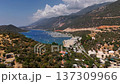 Aerial view of Kas marina with yachts anchored in a turquoise Mediterranean bay surrounded by mountains and green hills. Scenic coastal landscape in Antalya region, Turkey. 137309966
