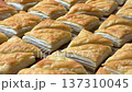 A tempting array of golden-brown puff pastries fresh from the oven, showing delicate, flaky layers and a crispy texture. Perfect for bakery menus, food blogging, or culinary concepts. High quality 4k 137310045