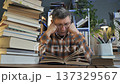 Tired mature man studying with stack of books at home desk 137329567