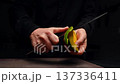 Chef peels mango with knife, showcasing continuous slicing action in kitchen 137336411