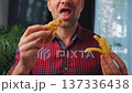 Junk food advertisement concept. Man eating fried chicken, enjoying fast food. 137336438