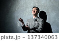 A Japanese man in a suit giving a presentation using a pin microphone 137340063