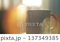 Steam rising from ceramic mug in warm morning sunlight 137349385