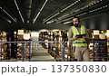 Employee working as a call center agent within distribution center. Using headset and tablet to handle complaints, shipment tracking with AWB tags and delivery status for e-commerce operations. 137350830