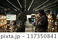 Military officer using AI-powered tools in warehouse at military base, monitoring artificial intelligence software on laptop. Machine learning and neural networks supporting tactical operations. 137350841