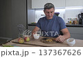 Mature man eating healthy breakfast with nuts raisins and tea at kitchen 137367626