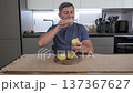 Mature man slicing fresh apple with knife preparing healthy snack at kitchen 137367627
