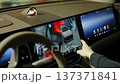 A driver uses a touchscreen in a modern car. 137371841