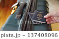 Hand placing United States passports on travel suitcase preparing for trip 137408096
