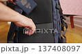 Man placing United States passport into backpack, travel preparation concept 137408097
