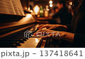 Woman playing piano with elegant hands on keyboard in warm atmospheric lighting with bokeh background in cozy interior setting 137418641