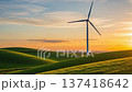 Wind turbine spinning in golden sunset light over green rolling hills countryside landscape for renewable energy power generation 137418642