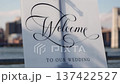 Sophisticated Outdoor Wedding Sign Featuring Calligraphy Against Blurred Urban Cityscape Background 137422527