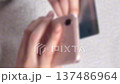 【縦動画】ぼかし背景素材: クレジットカードを持ち、スマートフォンでカード情報を入力する女性の手元の 137486964