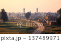 Sunrise over fields and mosques along a dusty road in a rural setting in the morning light 137489971