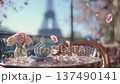 Coffee sits on a table with flowers and petals near the Eiffel Tower in Paris during springtime 137490141