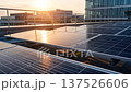 Green energy business rooftop solar panel office roof installation captures clean power production with warm sunset sky reflection modern sustainable workspace renewable sun light urban architecture 137526606