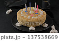 Whole holiday cake with crumbly shortcrust pastry and mini meringue. Birthday cake with extinguished candles. Homemade baking. Black background, selective focus, close-up. Zoom. 137538669
