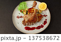 Duck leg confit with Brussels sprouts, baked potatoes, thyme, orange and lingonberry sauce. Traditional French cuisine. Selective focus, close-up, black background. Zoom. 137538672