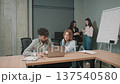 Business meeting in modern office with four professionals focused on work and discussion 137540580