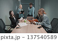 Business meeting with a diverse group discussing project details in a modern office setting 137540589