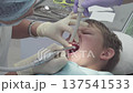 Dentist works on a young boy's chipped tooth in a dental clinic. The procedure involves polishing the broken surface to ensure it is smooth and safe 137541533