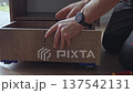 Closeup of hand holding wooden drawer box with metal runners on floor 137542131