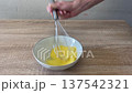 hand whisk ringing when beating eggs in ceramic bowl 137542321