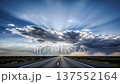 Long empty asphalt highway leading into the distance with a dramatic cloudy sky and strong sun rays breaking through, journey and success concept 137552164