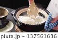 A chef mixing freshly cooked rice with a ladle 137561636