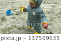 Toddler in Hooded Raincoat Near Sandbox Playground 137569635