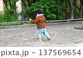Toddler in jacket on stone courtyard 137569654
