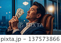 Successful Asian businessman enjoying money smell sitting in luxury leather chair at modern office during evening hours 137573866