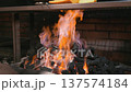Tilt up shot of charcoal grill with food cooking over open fire in restaurant kitchen 137574184