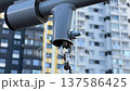 Close up of a moving swing mechanism with a blurry building background 137586425