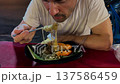 Man eating thai glass noodles with shrimp at a street food market 137586459