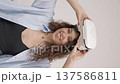 Young woman in VR glasses using modern technology creating room design, moving hands in air, standing in new apartment during renovation. Virtual reality and repair concept	 137586811
