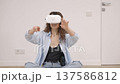 Young woman in VR glasses using modern technology creating room design, moving hands in air, standing in new apartment during renovation. Virtual reality and repair concept	 137586812
