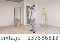 Young woman in VR glasses using modern technology creating room design, moving hands in air, standing in new apartment during renovation. Virtual reality and repair concept	 137586813
