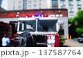 Fire station. A firefighter stands next to a fire engine. Fire trucks, their lights on, are ready to go. Realistic 4k animation. 137587764