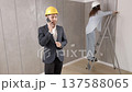 A young businessman holds a phone in his hands and checks the work of a designer in creating an interior in a room. The concept of repair on a modern design 137588065
