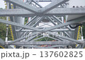 Rigid steel framework and support towers during movement of Ferris wheel. Close up of cross bracing beams and truss system creating strong structural construction of popular observation attraction. 137602825