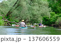 Family and solo traveler paddling kayaks on river during summer slow motion expedition connecting with nature, outdoor adventure, water tourism, slow river journey 137606559